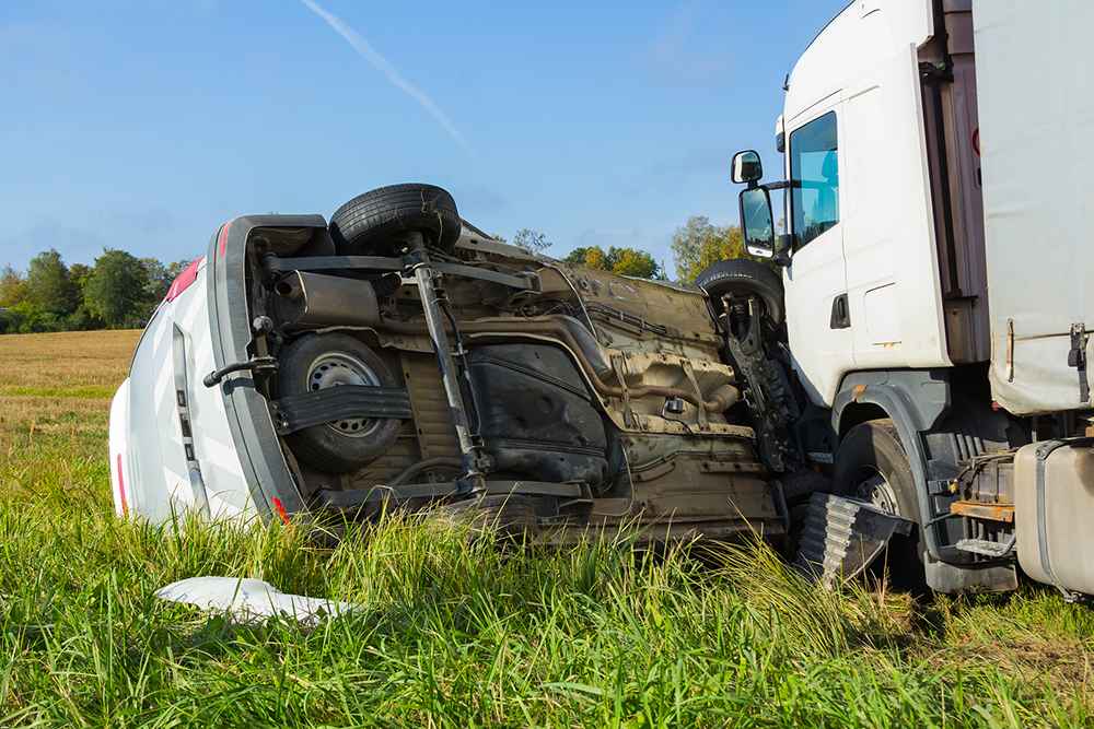 car flipped after a collision with a heavy truck
