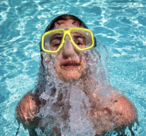 a person in swimming pool with yellow swimming glasses