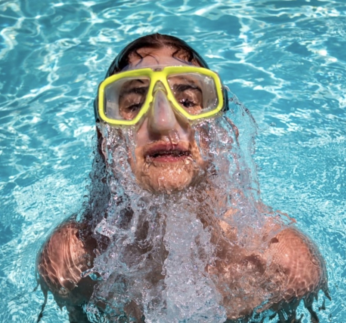 a person in swimming pool with yellow swimming glasses