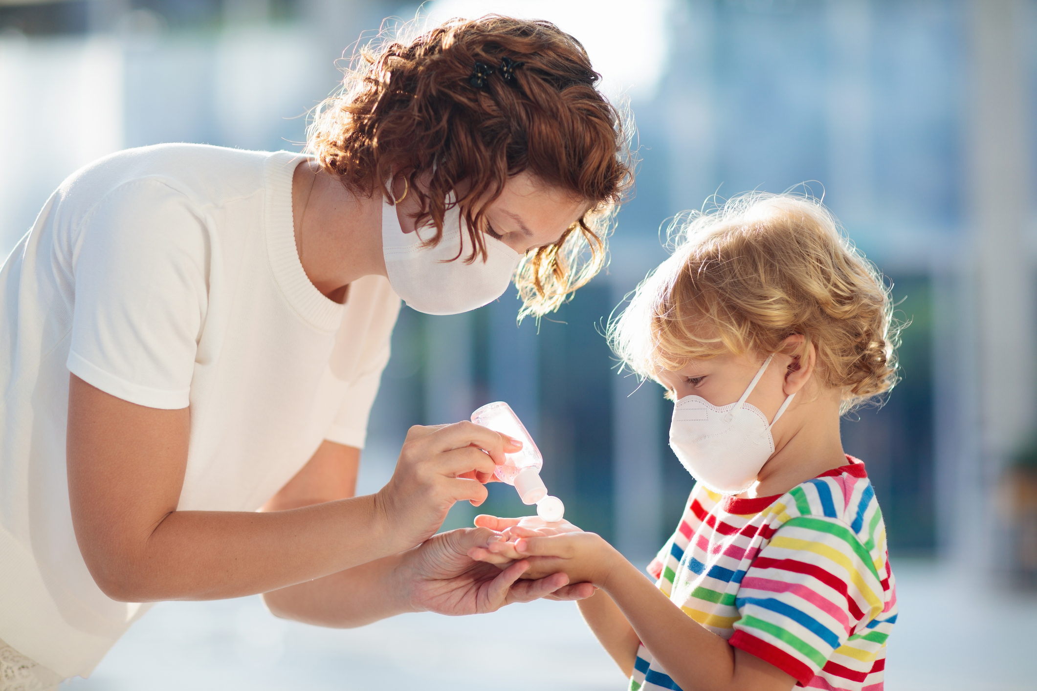 Mother and child with face mask and hand sanitizer