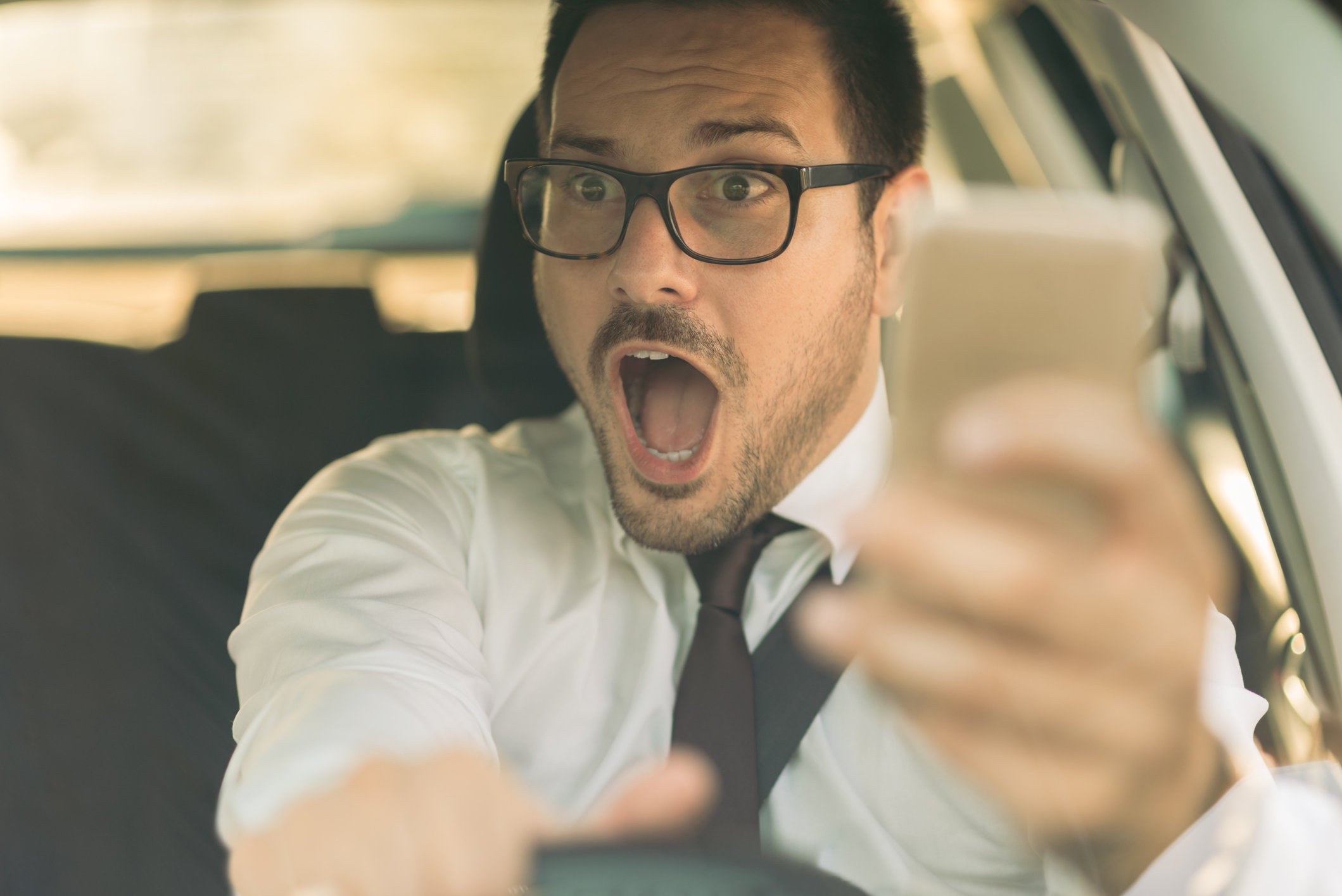 A man holding a phone | Risky driving behavior