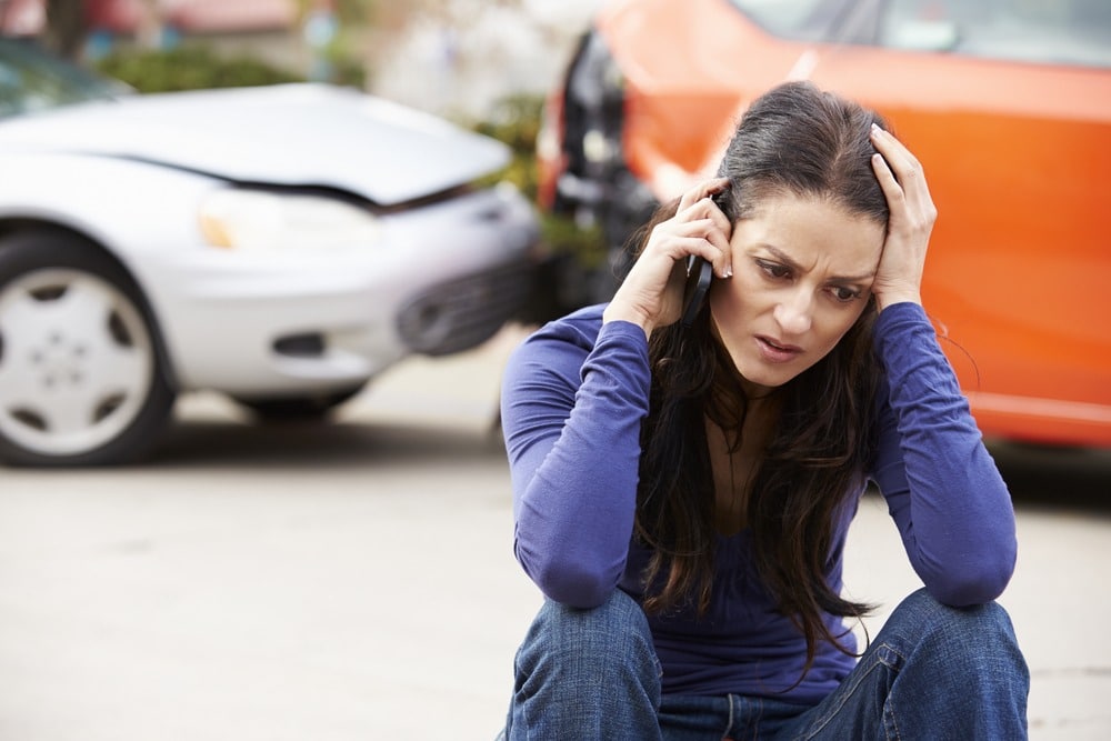 A woman calls a lawyer after a car accident on the road